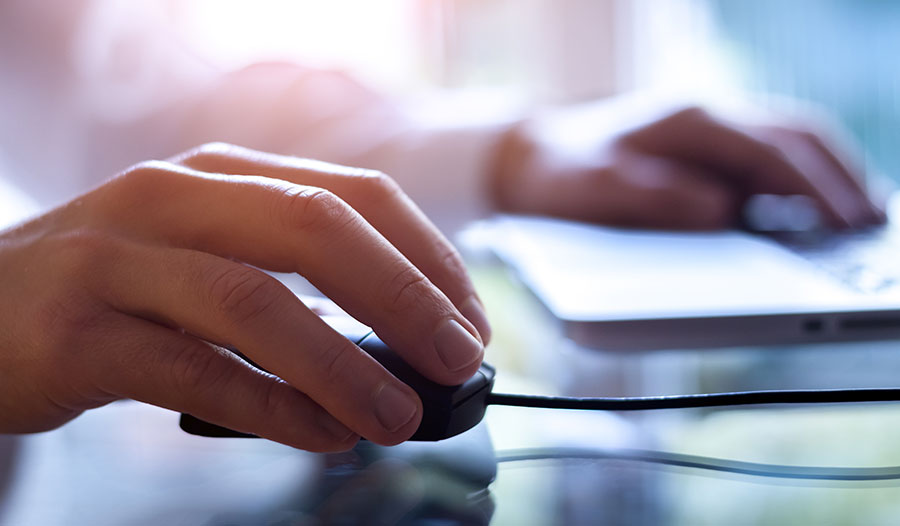 Person's hand gripping a computer mouse