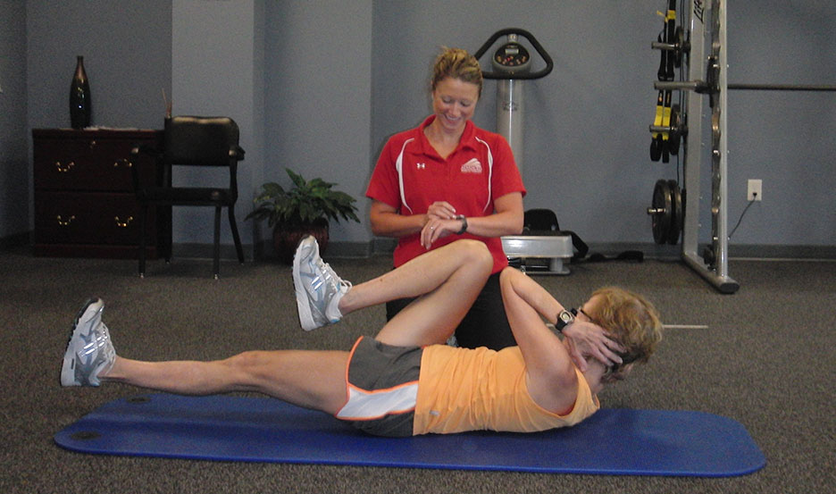 Personal Trainer timing a man as he works out in